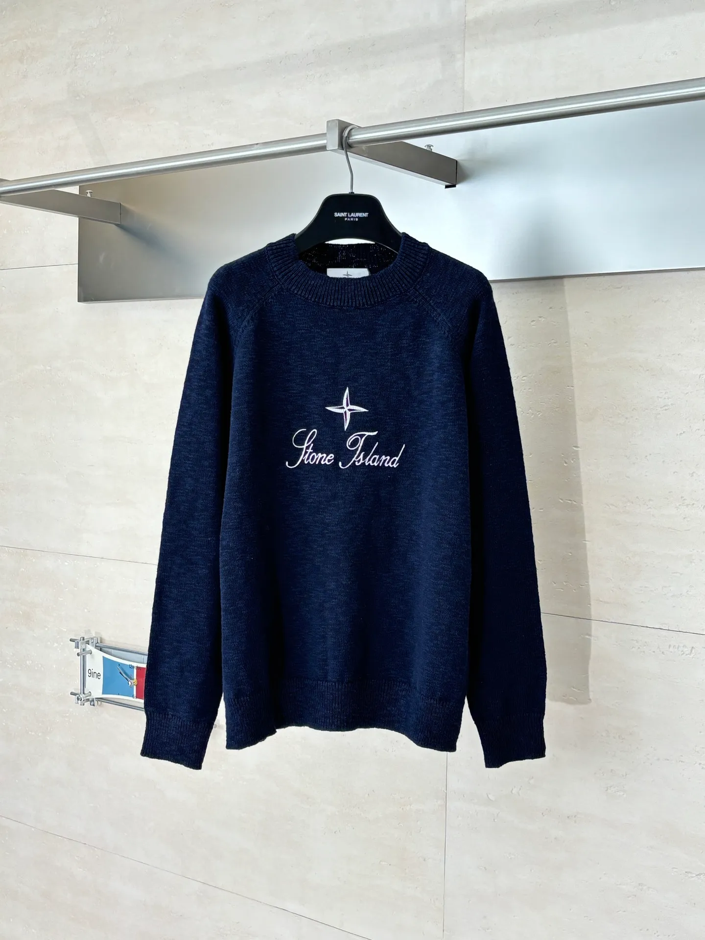 P460 STONE ISLAN*/Stone Island FW25 Holiday Limited Threaded logo embroidered pullover knitted sweater. The fabric is made of imported ultra-fine merino wool yarn, which has been combed to remove impurities and anti-pilling. The plain base is woven with a 14-needle circular machine. The yarn is first dyed and then woven to make the navy blue color rich and not easy to fade. The body is designed with a raglan sleeve structure, the shoulder panels are laser positioned and cut, and the splicing joints are seamlessly connected using embedded clip technology, giving you a non-restrained feeling when worn. The brand logo and star pattern on the chest adopt a combination of hand-applied embroidery + flat embroidery, using high-elastic polyester-cotton thread. The stitch density is controlled at 8 stitches per centimeter. The outline of the pattern is clear and three-dimensional, and it is wear-resistant and does not fall off. The neckline is designed with a ribbed round neck. The rib tissue is pre-shrunk and shaped by high temperature. It has excellent resilience and is not easy to loosen. The cuffs and hem are also ribbed with the same material, and are reinforced with the body through overlock sewing technology. The overall tailoring follows ergonomics, and each process undergoes quality control testing. From yarn weaving to finished product sewing, the precision of details is controlled throughout the process to create knitted items with both functionality and design. The overall wiring is straight and delicate, the fabric is comfortable and soft, and the color is consistent without color difference. Size: S/M/L/XL